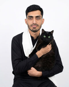 Teenage Boy in Black Kurta Holding Fluffy Black Cat_Gemini Prompt Copy Past