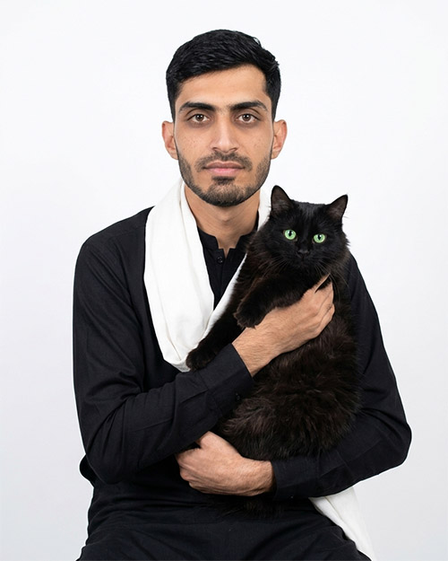 Teenage Boy in Black Kurta Holding Fluffy Black Cat_Gemini Prompt Copy Past